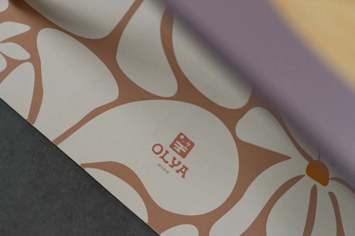 3. Close-up of OLYA KIDS logo on daisy-patterned floor mat
