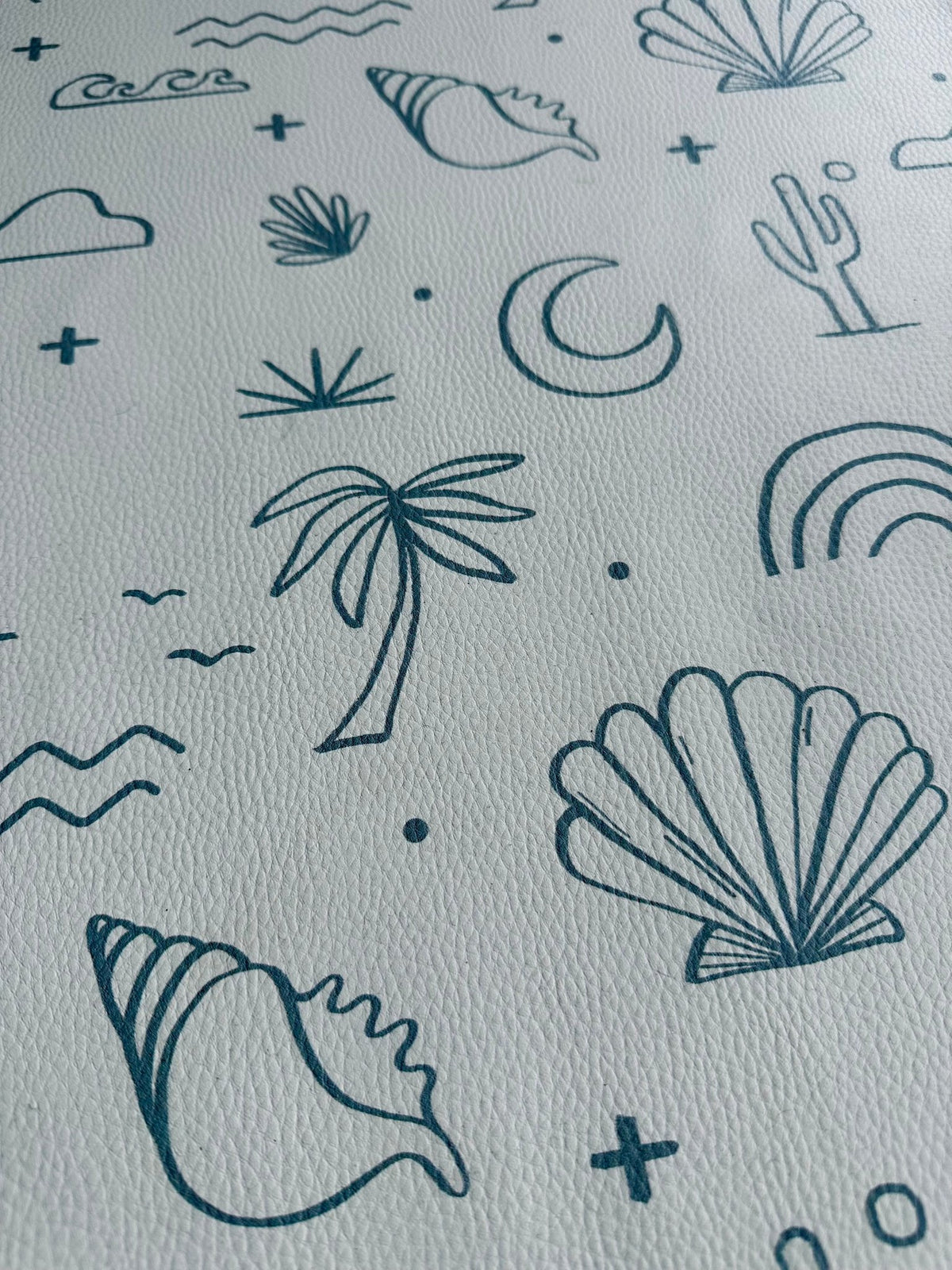 3. Close-up of OLYA KIDS floor mat with palm trees, shells, and waves pattern