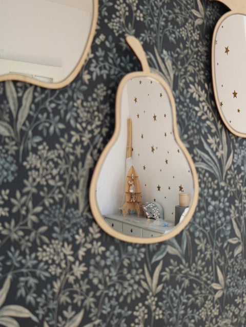 1. Pear-shaped mirror with natural plywood frame on floral wallpaper, reflecting a nursery room with star decals.