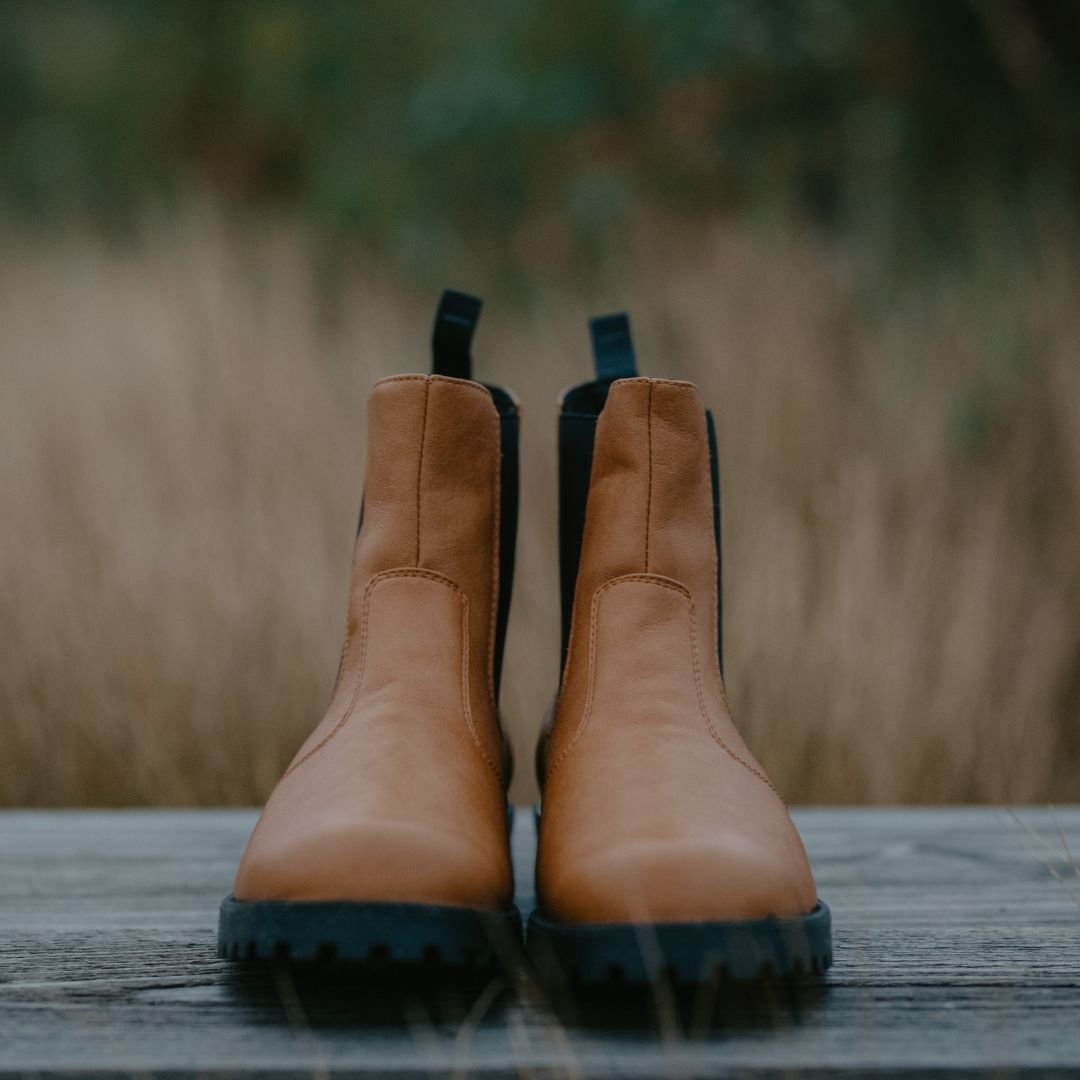 4. KIRA 3.0 Chelsea Boots in brown, shown on wooden surface with natural background