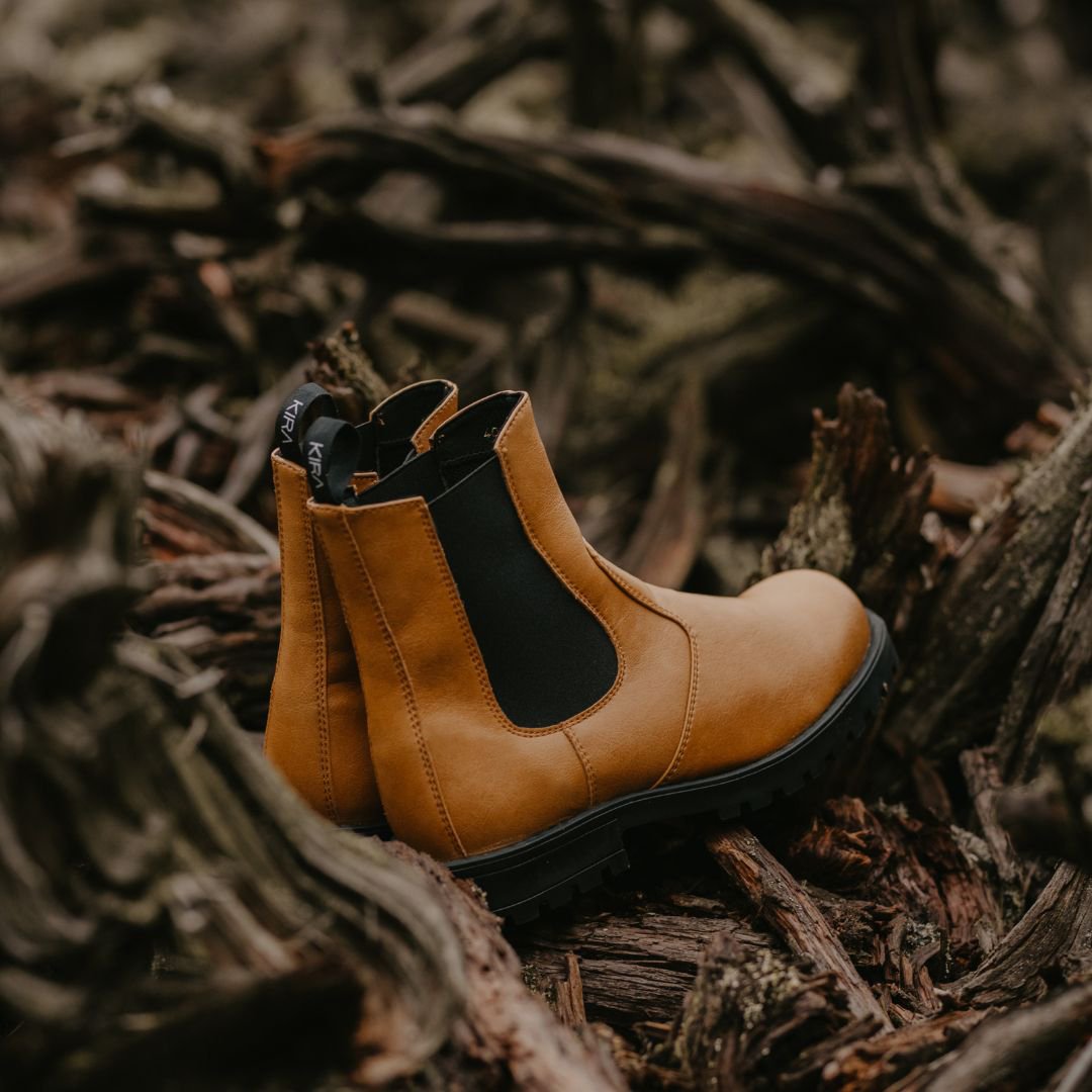 5. Side view of KIRA 3.0 Chelsea Boots in brown, displayed on rustic wood