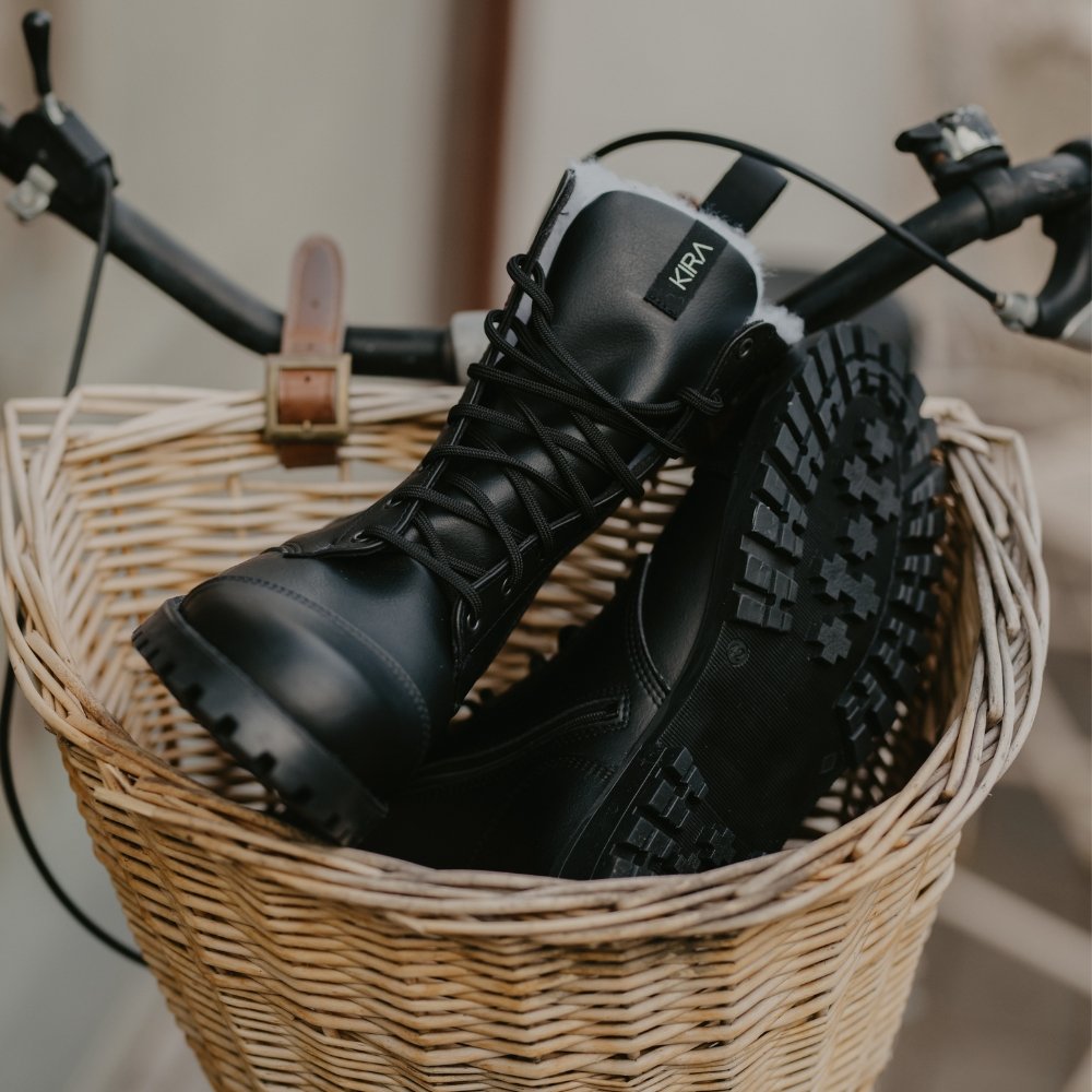 1. KIRA 4.0 black boots in wicker basket, showcasing non-slip soles and recycled microfiber upper