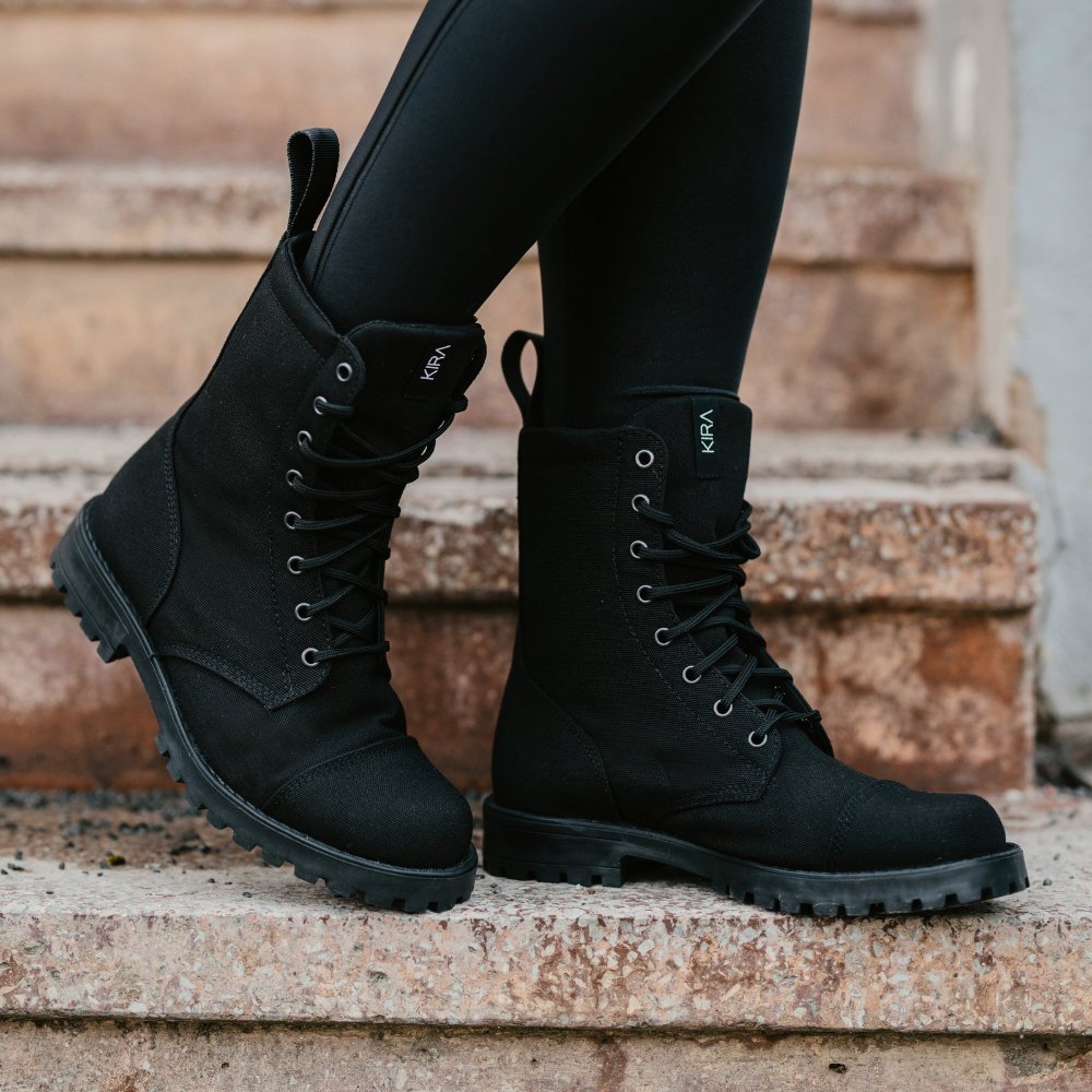 1. Women's KIRA 5.0 black boots styled with leggings, shown on steps for a casual look