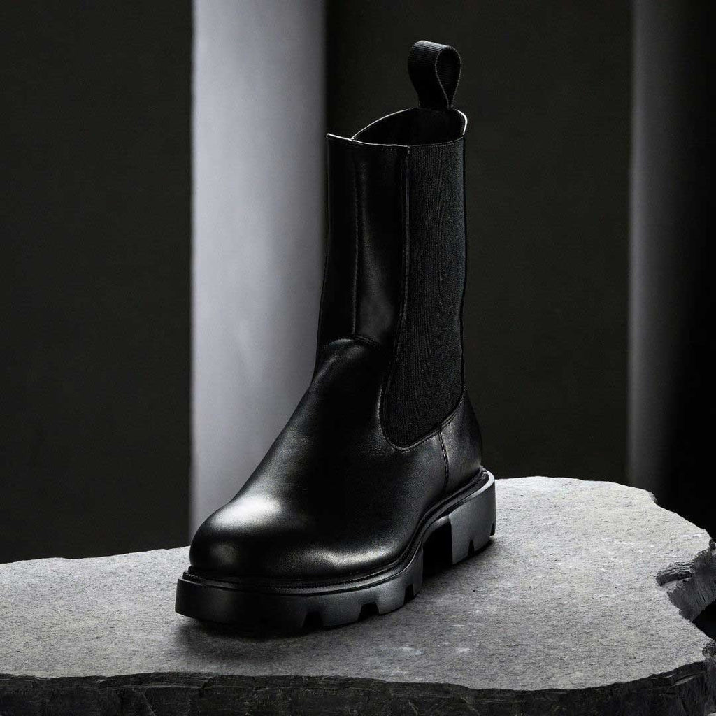 3. Black KIRA Chelsea Rebel boot with microfiber upper and bold sole on stone surface in studio lighting