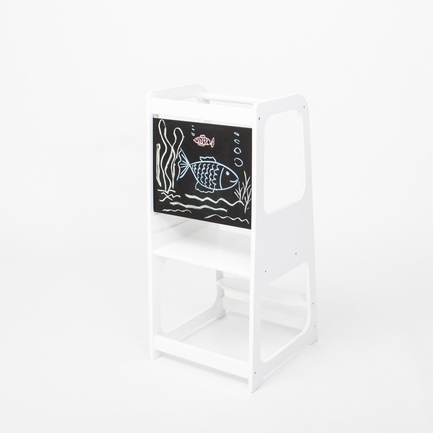 2. White Montessori kitchen helper tower with blackboard panel featuring fish drawing, shown in a studio setting
