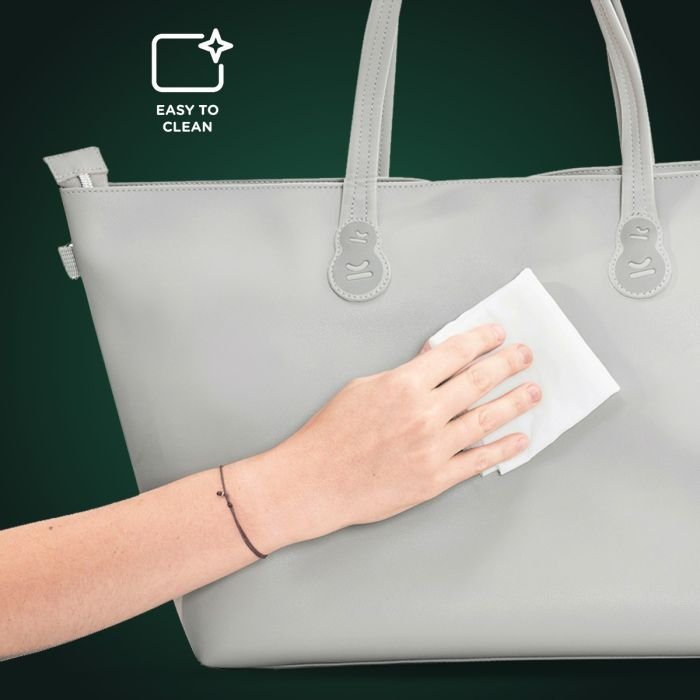 3. Close-up of hand cleaning light grey Kinderkraft Treasurebag with text 'Easy to Clean'