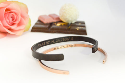 1. Black and rose gold men's bracelets with engraved coordinates, styled with a rose and chocolate