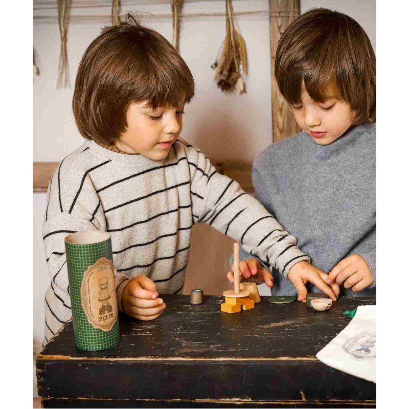 1. Two children assembling wooden stick figure puzzle on a dark table, one wearing striped sweater, the other in grey
