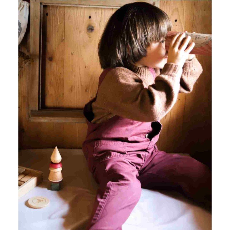 1. Child in red overalls sitting indoors, playing with Wooden Story LALA Stick Figure Puzzle and packaging