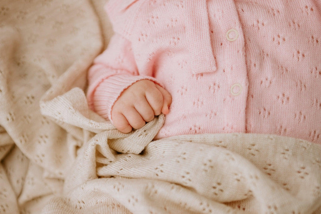 5. Close-up of baby hand holding cream merino wool blanket