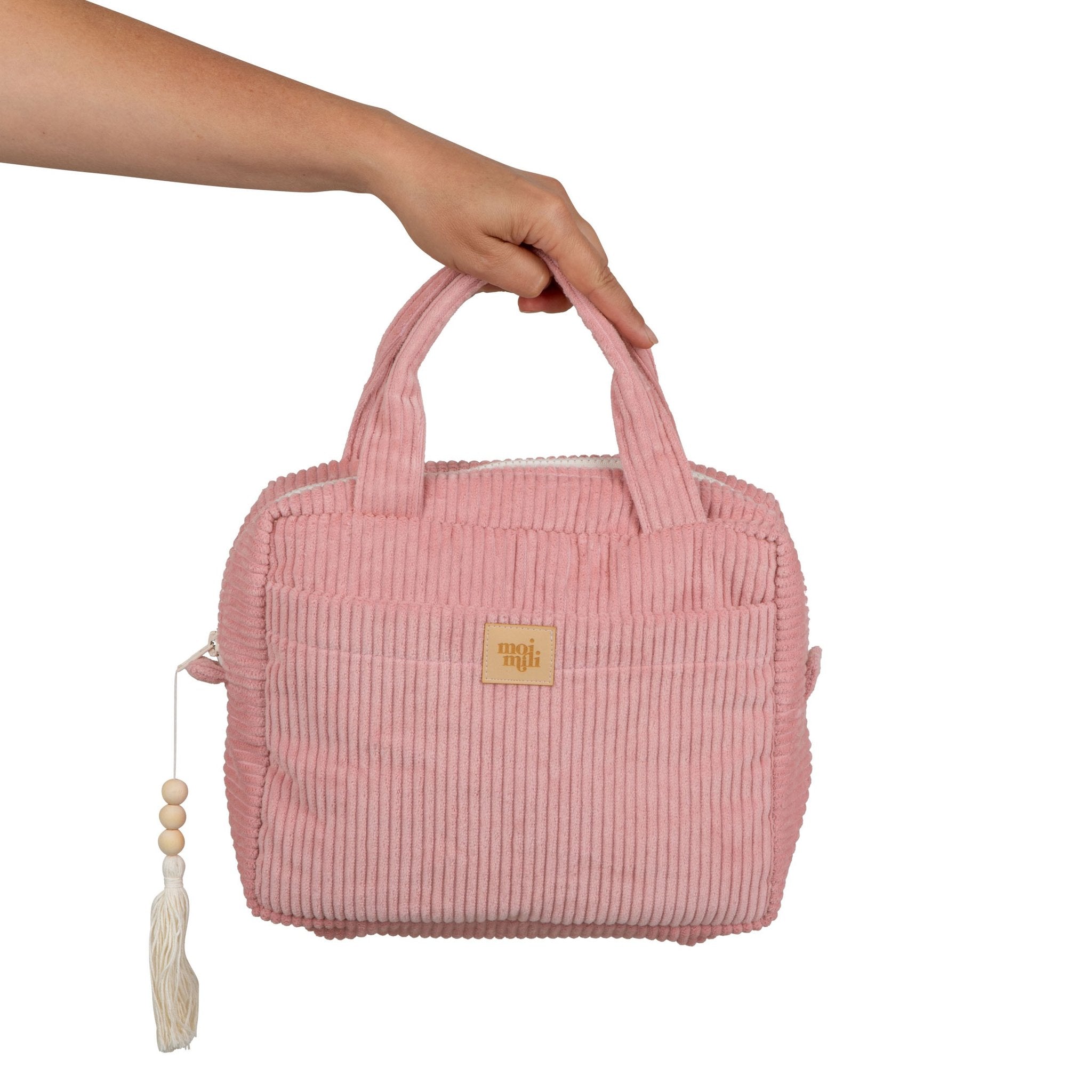 2. Hand holding Moi Mili large baby pink makeup bag with ribbed texture