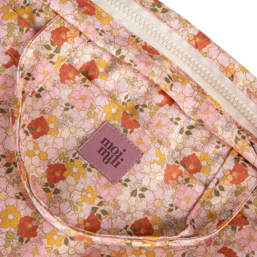 3. Close-up of Moi Mili logo on floral print fabric of large makeup bag