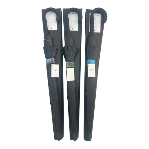 4. Flat lay of three packaged large stick umbrellas with black covers and visible Sky Lake design tags