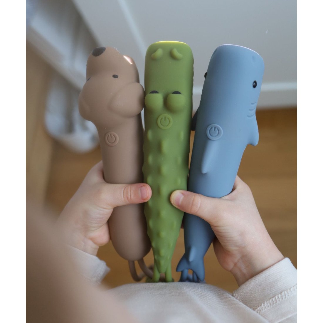 4. Child holding three silicone flashlights in dog, crocodile, and shark shapes, showcasing variety and fun design.