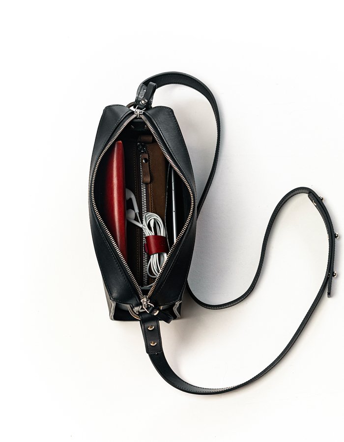 5. Inside view of black Stella Soomlais Treasure Box handbag showing organized compartments with items
