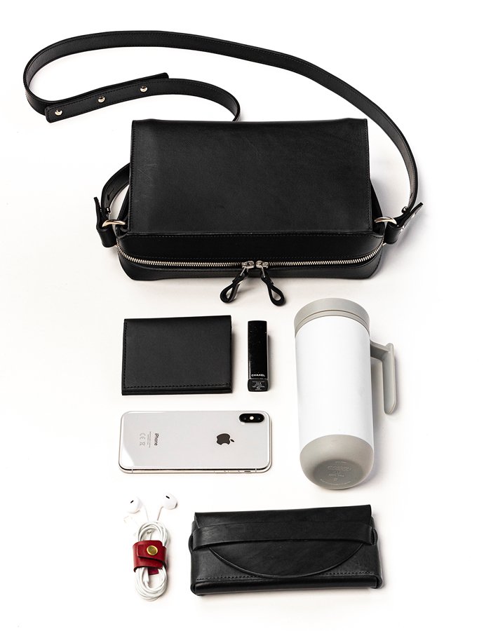 3. Black Stella Soomlais Treasure Box handbag with contents including phone, wallet, and tumbler laid out