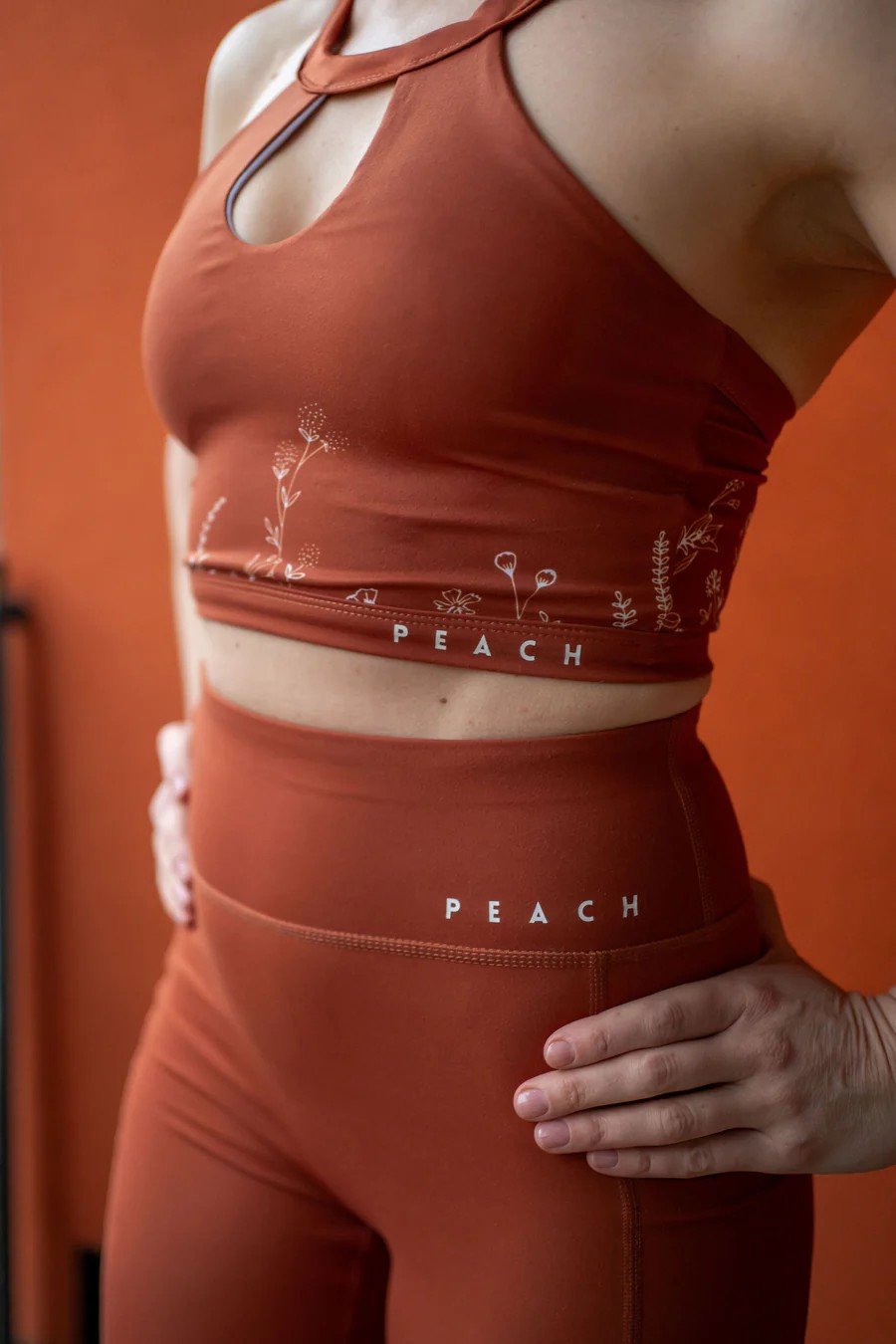 4. Side view of Peachlabel Wildflowers brown sports bra and leggings, featuring floral design and PEACH branding