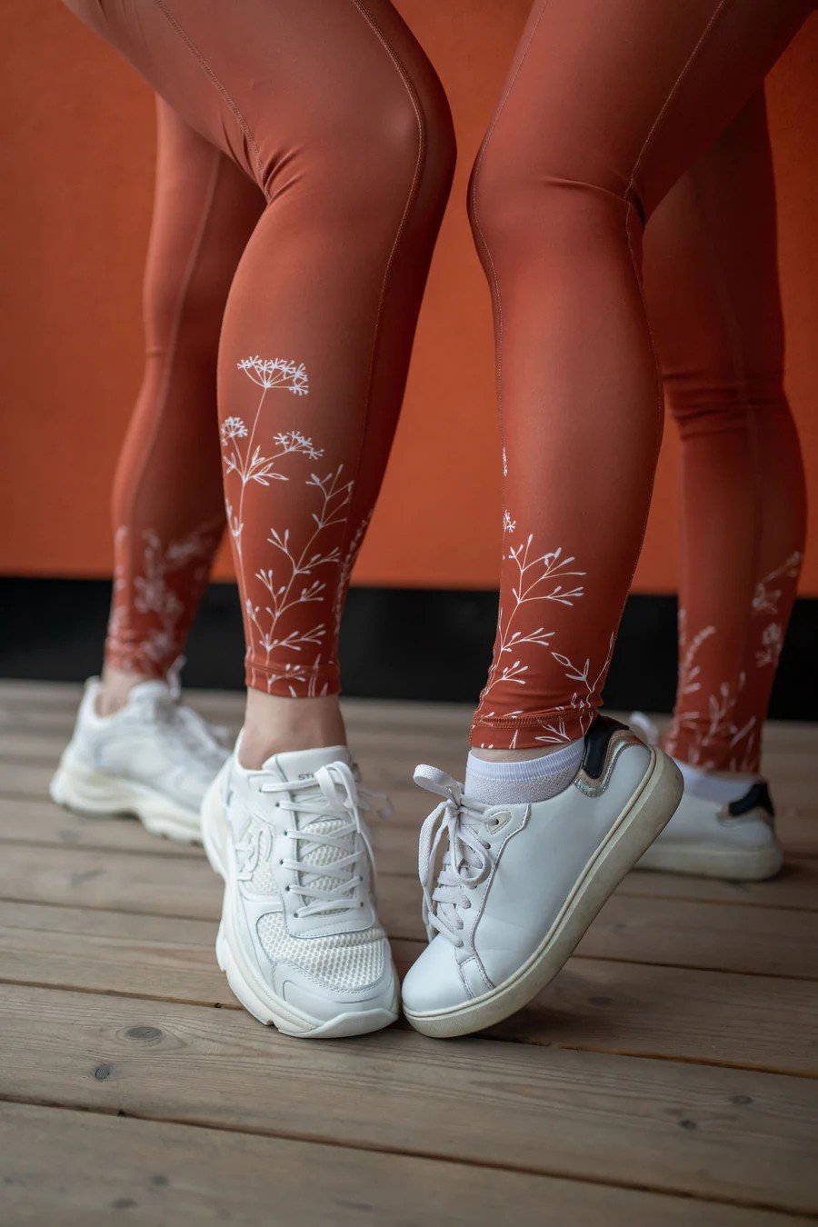 2. Close-up of women's legs in Peachlabel 'Wildflowers' brown leggings, highlighting floral design near ankles