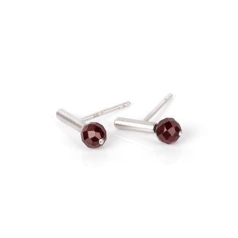 1. Pair of MyaMoon Light It Up earrings in silver with faceted red garnet stones on a white background