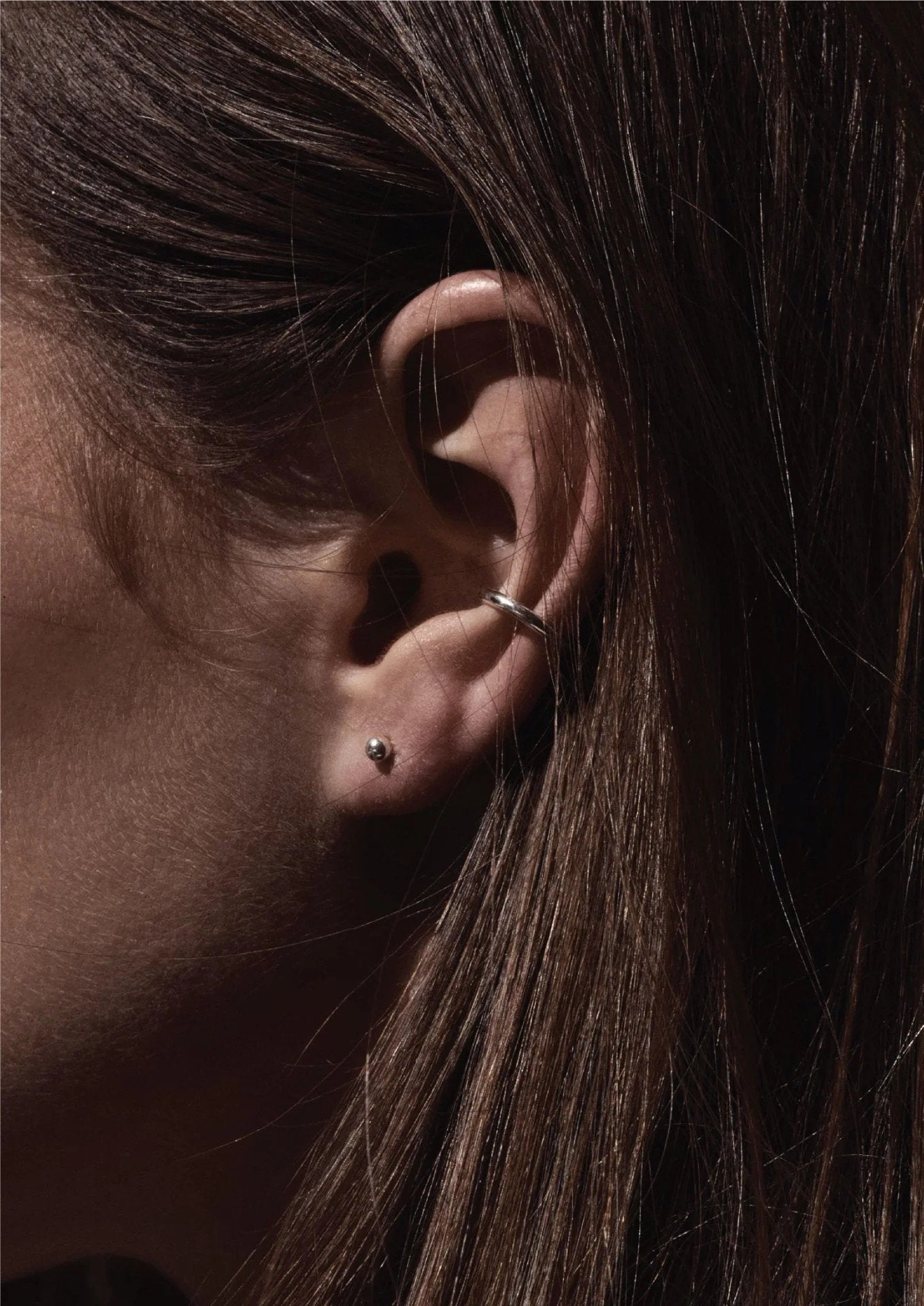 4. Close-up of women's silver Line Ear Cuff by NO MORE worn on ear