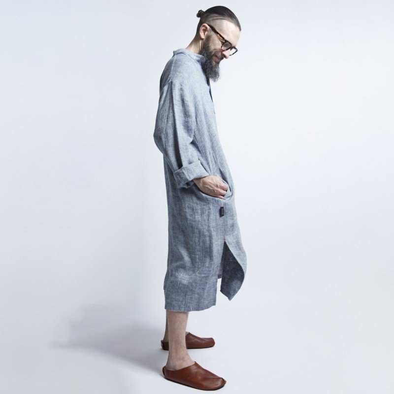 3. Side view of man in blue-gray linen dress with hands in pockets and brown shoes