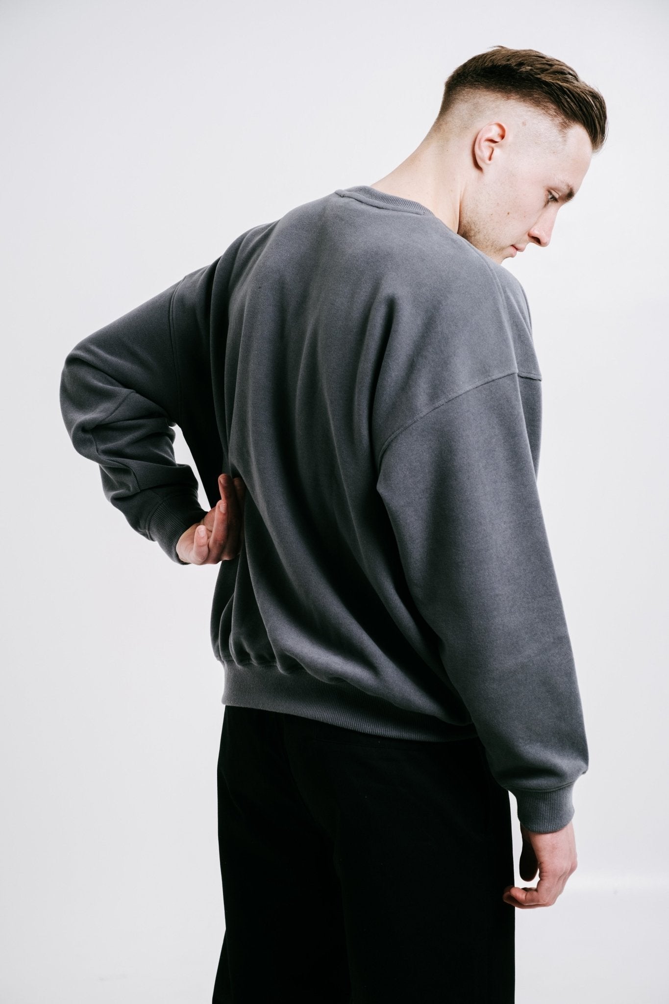 4. Back view of unisex anthracite Lion Sweatshirt by Sossu on male model in studio