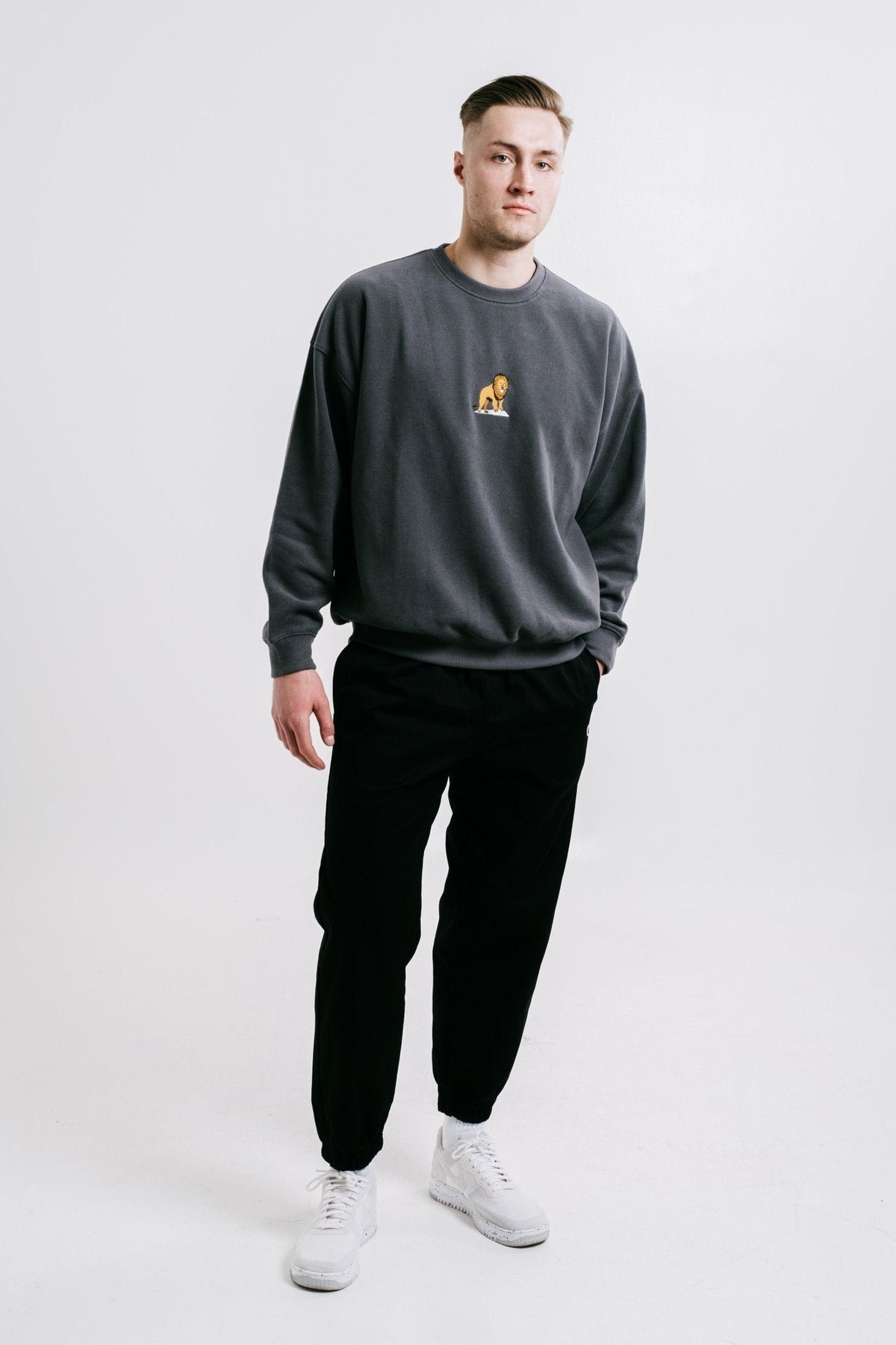 1. Unisex anthracite Lion Sweatshirt by Sossu worn by male model in studio setting