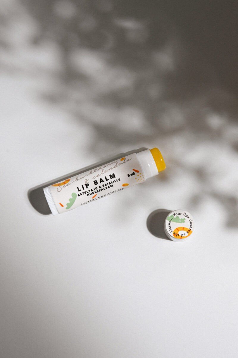 2. BONOBO Sea-Buckthorn & Calendula lip balm tube and cap on a white surface with shadow, showcasing product design and branding
