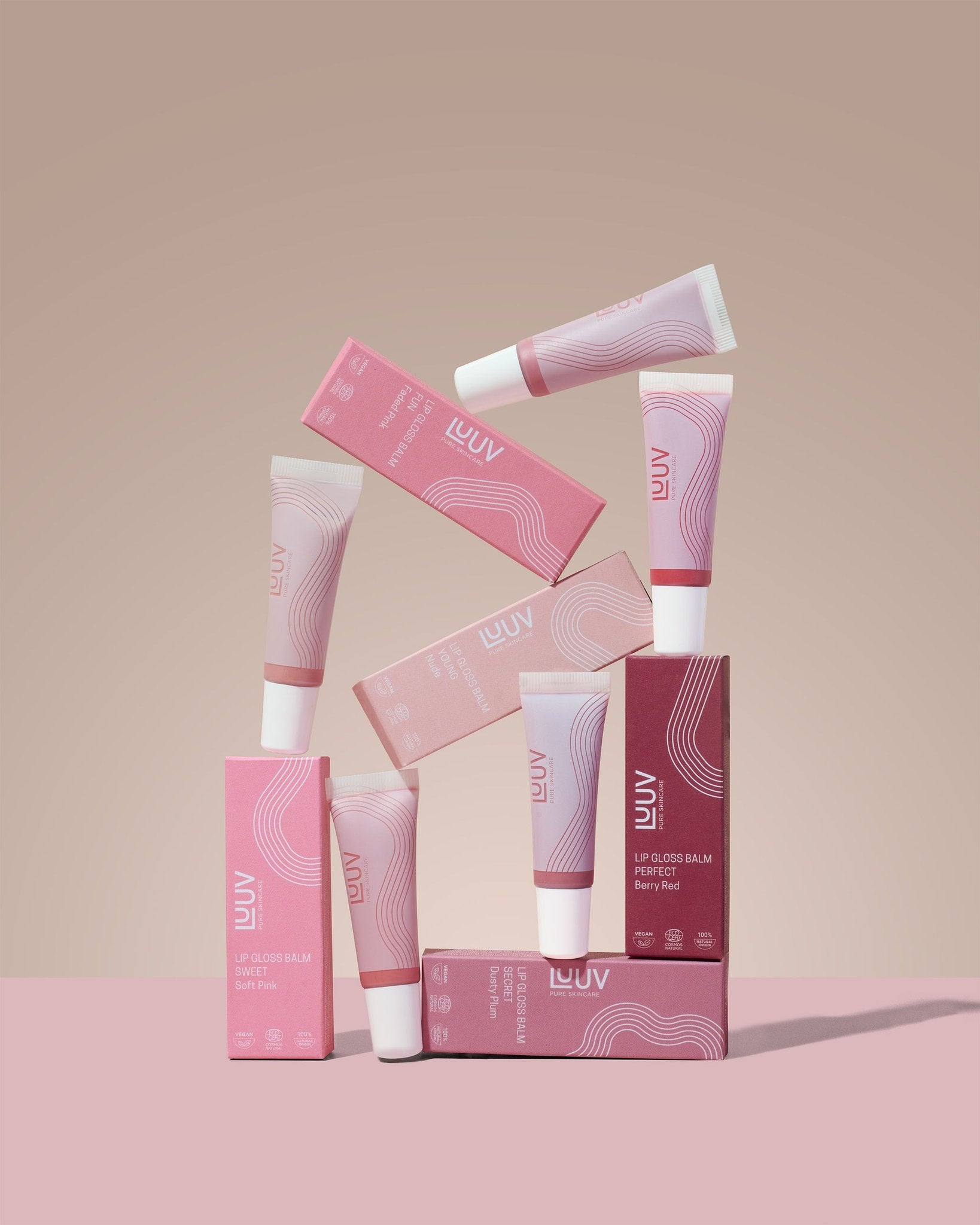 4. LUUV Lip Gloss Balm tubes and boxes stacked artistically, showcasing different shades and packaging