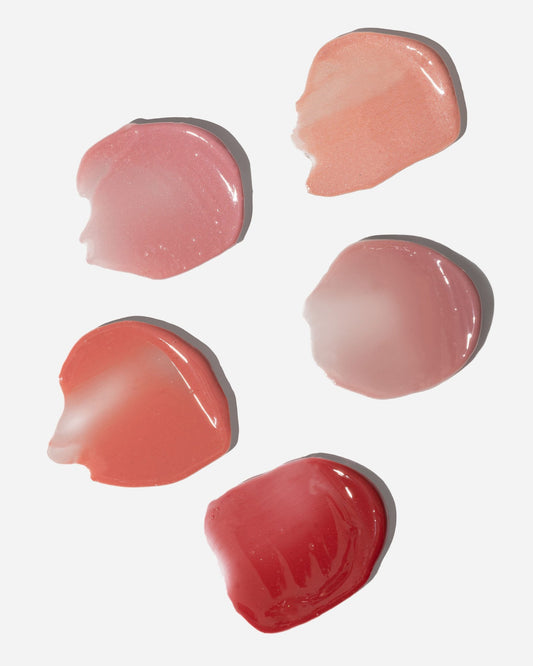 2. Close-up of LUUV Lip Gloss Balm swatches in various pink and red shades on white background