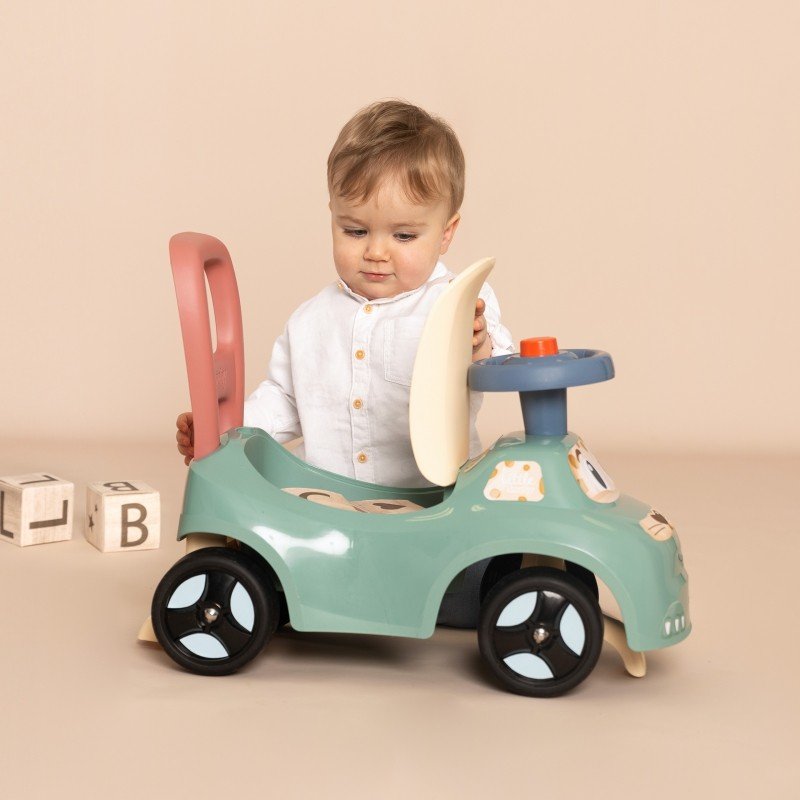 1. Toddler exploring Smoby Little Ride-on Pusher with open seat storage, indoor setting