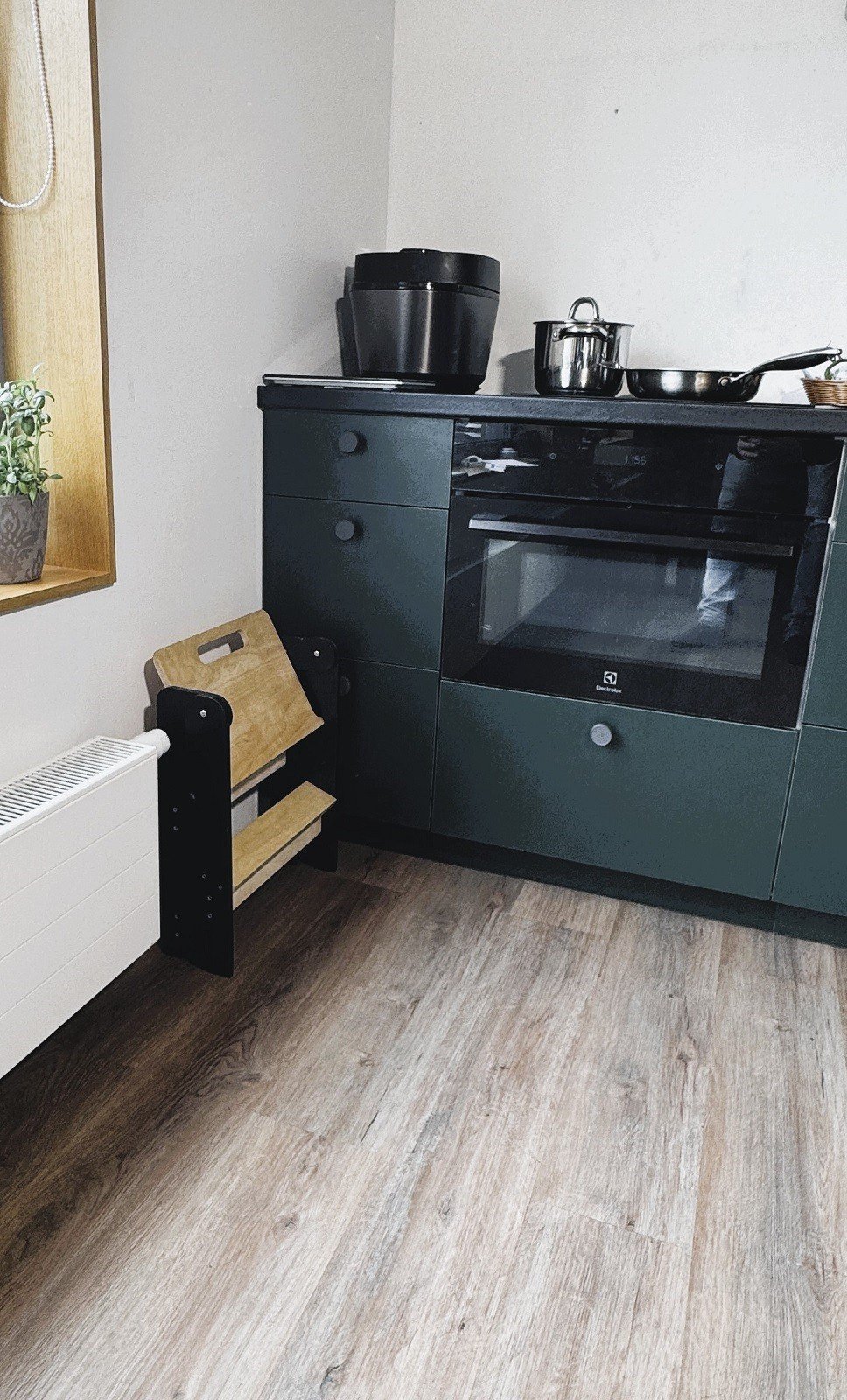 1. Wooden step stool folded and placed beside a kitchen cabinet