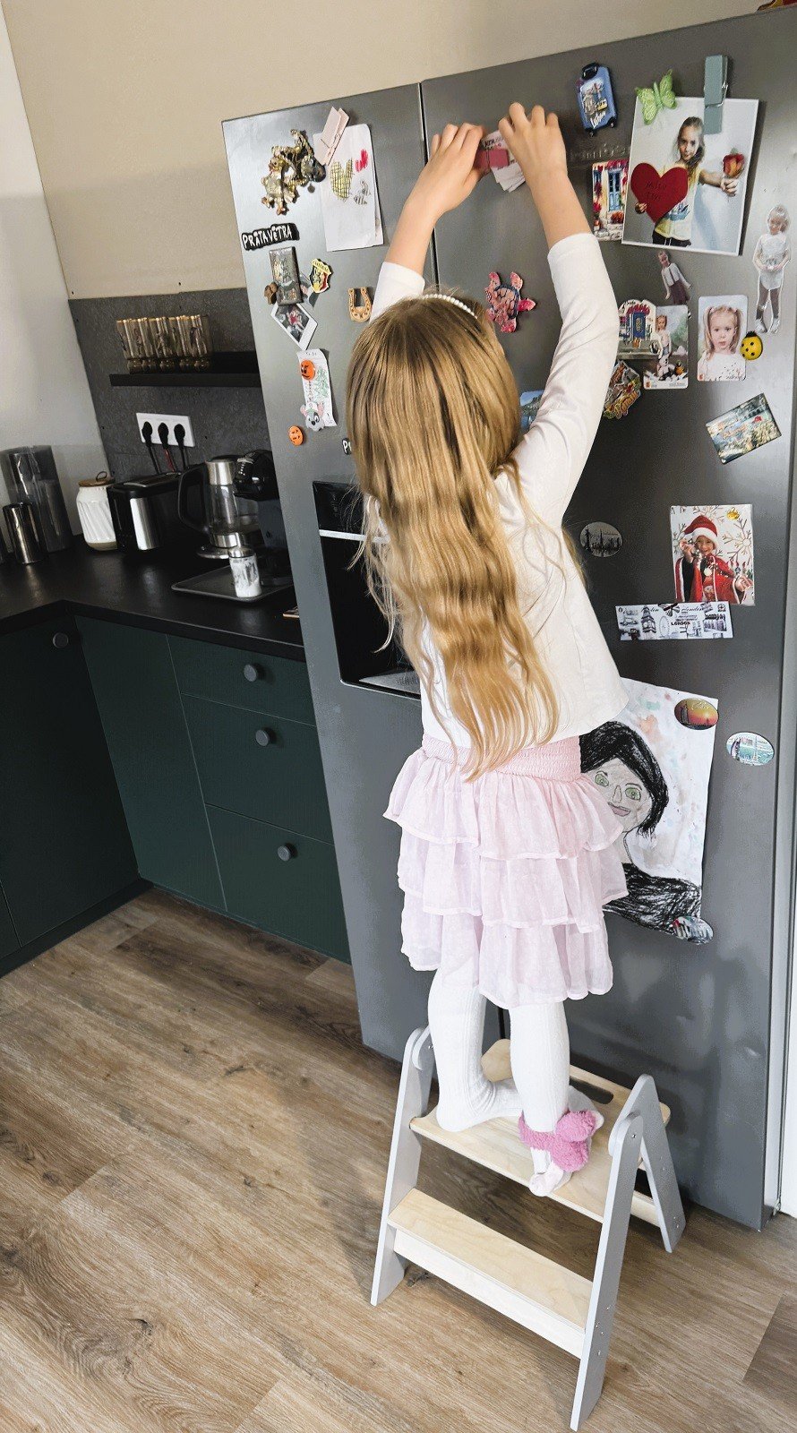 1. Girl using wooden step stool to reach items on a fridge