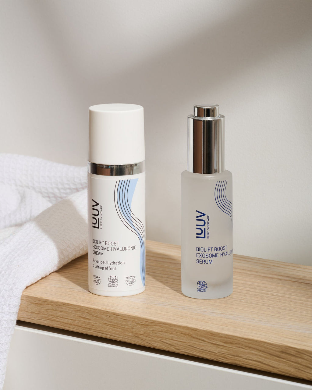 3. LUUV BioLift Exosome-Hyaluronic Serum and Cream displayed on a wooden shelf with a towel