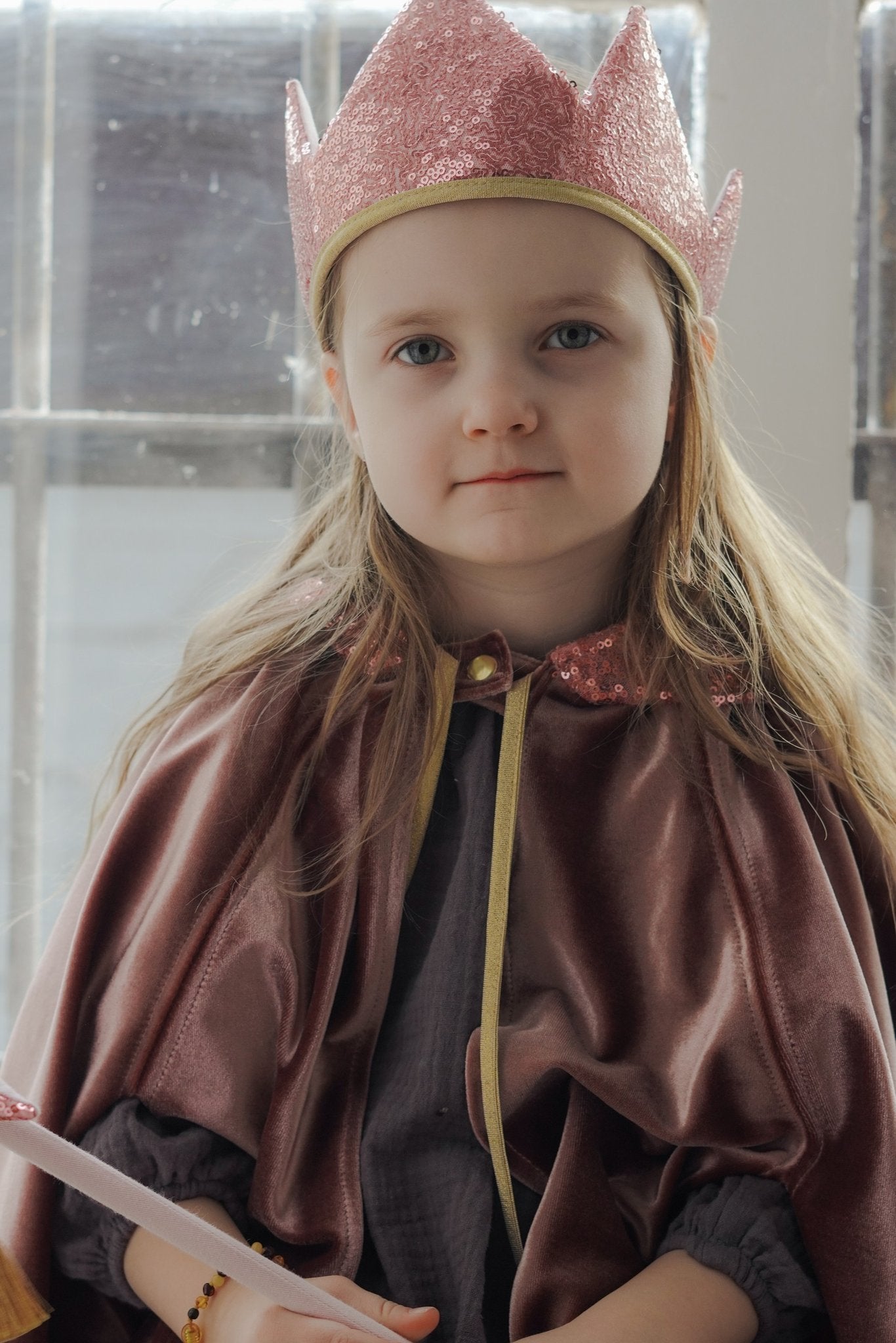 1. Girl in cosmic pearl cape and pink crown, holding a wand, highlighting the cape's velour material and fantasy theme