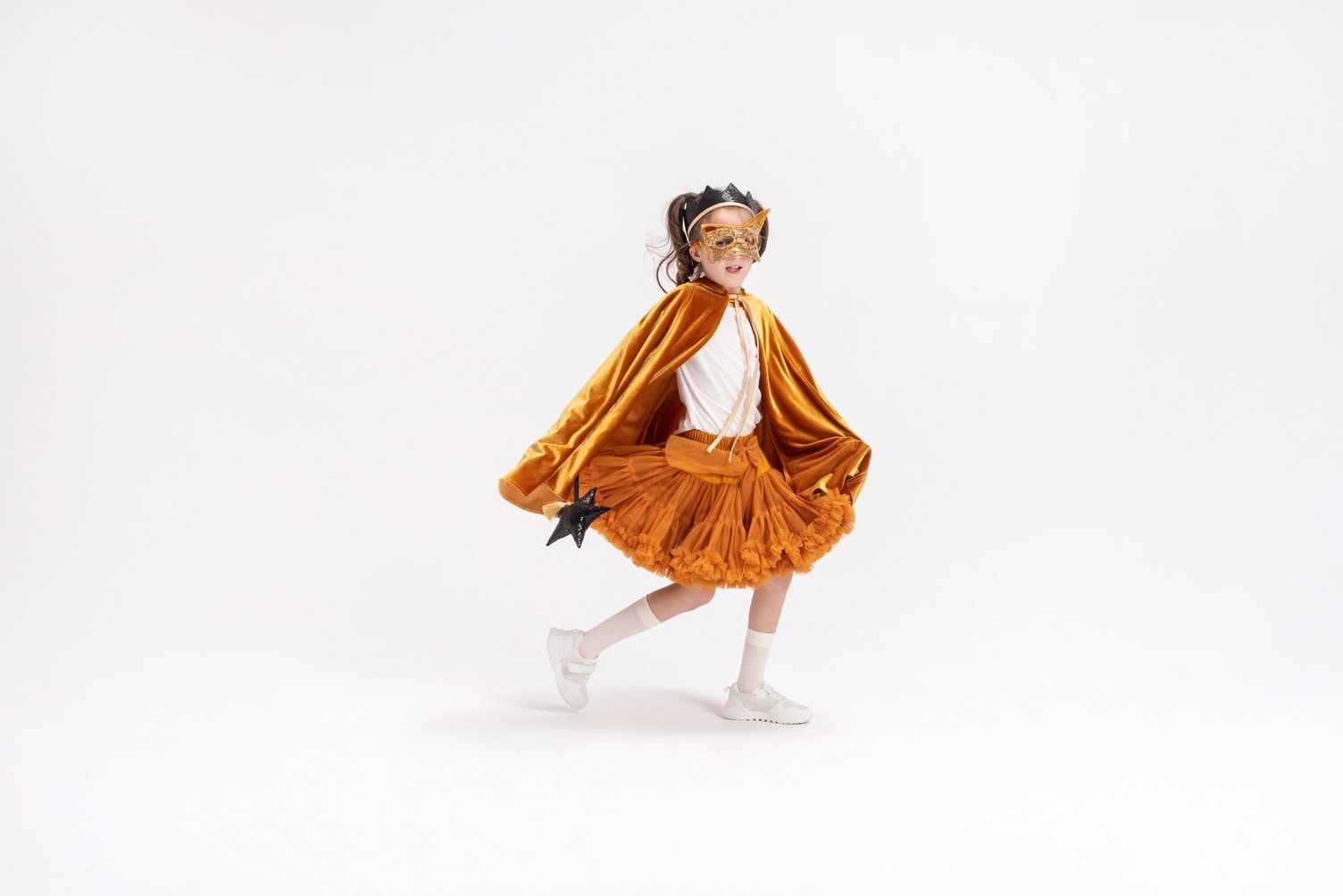8. Child in golden cape and crown posing in studio