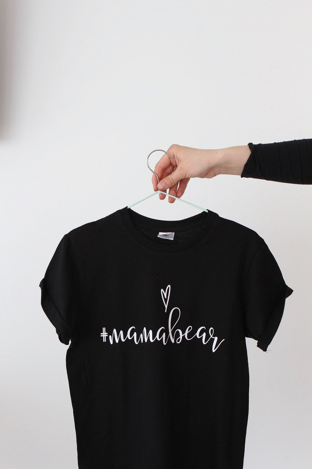 2. Black Mamabear T-shirt by Black Giraffe Brand with rolled-up sleeves, shown on hanger