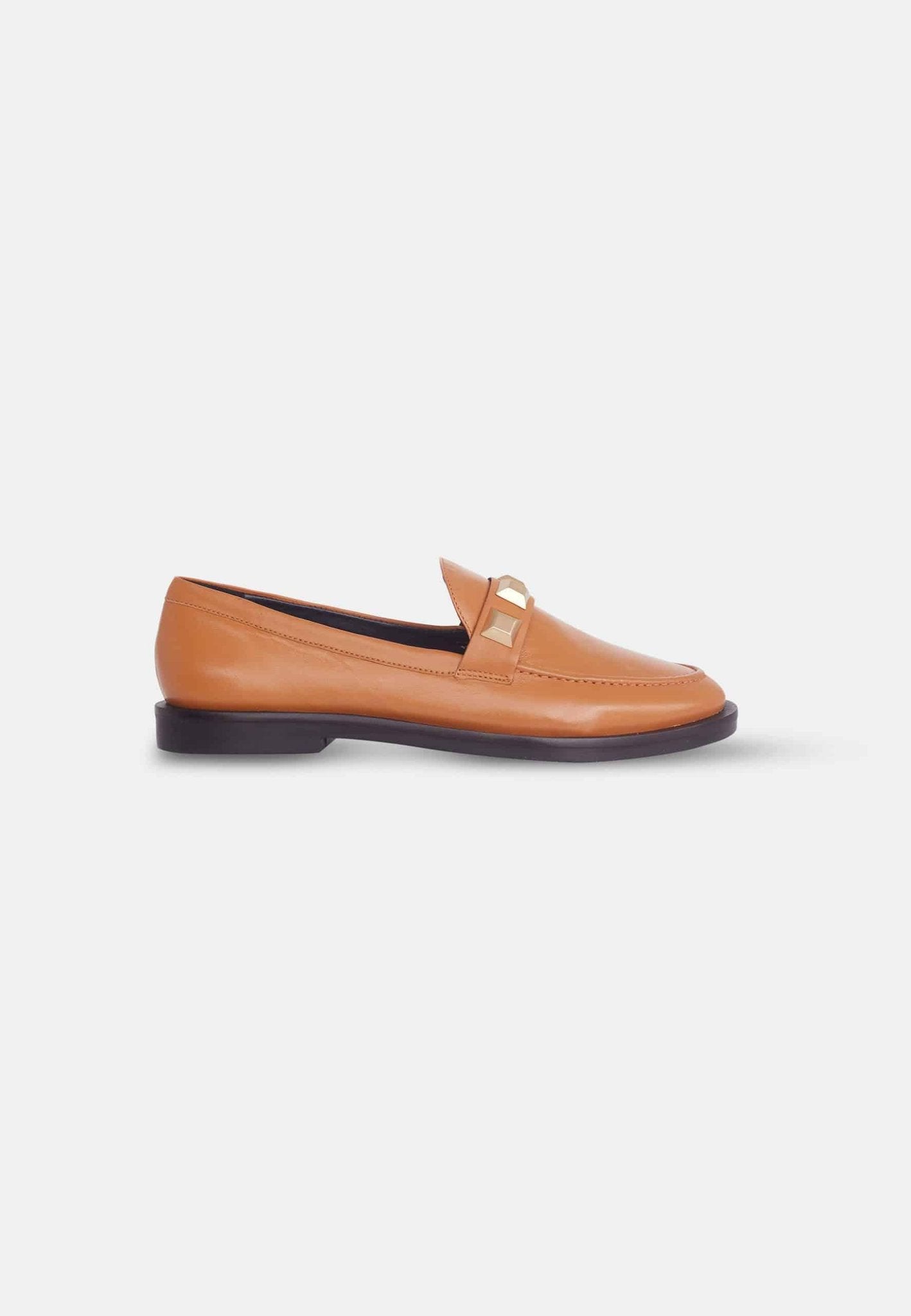 13. Angled view of black Mangará Caete leather loafers with metal studs, studio setting