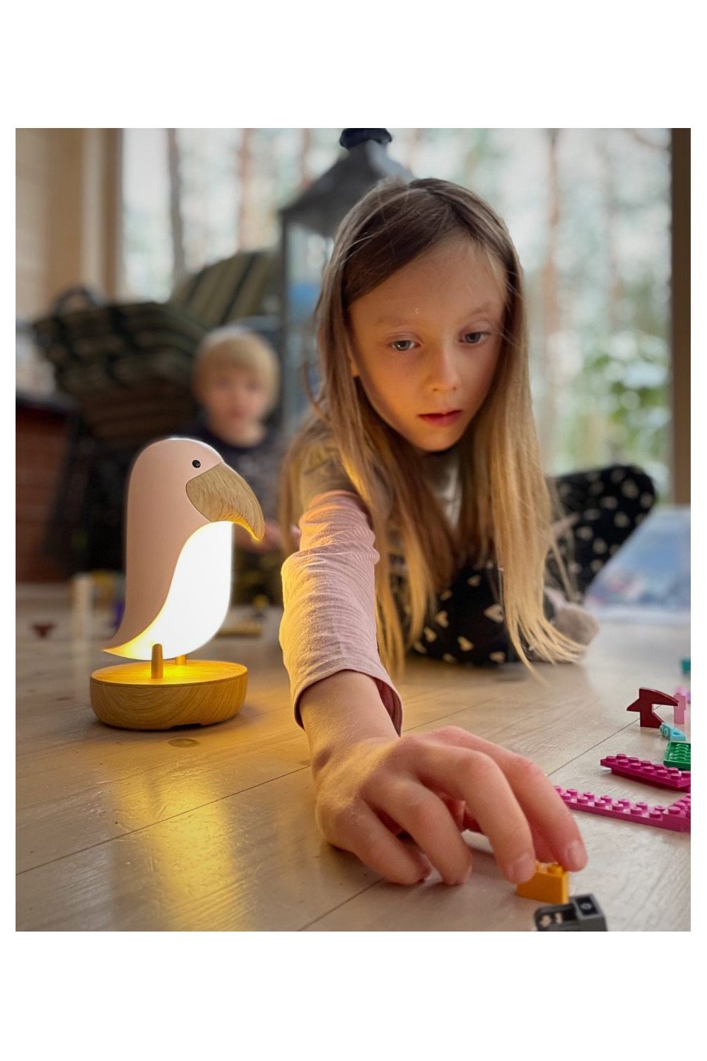 1. Girl playing on floor with bird-shaped lamp in background