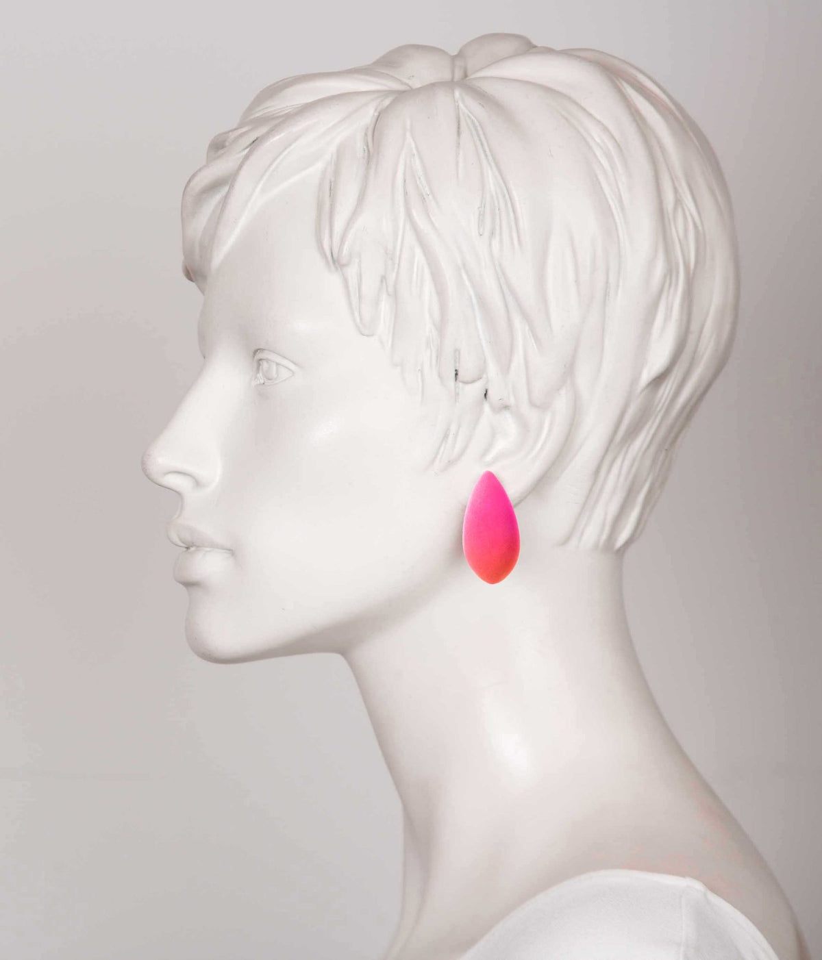 1. Side profile of mannequin wearing pink teardrop-shaped Mega Pitayaberries earring by Tanel Veenre