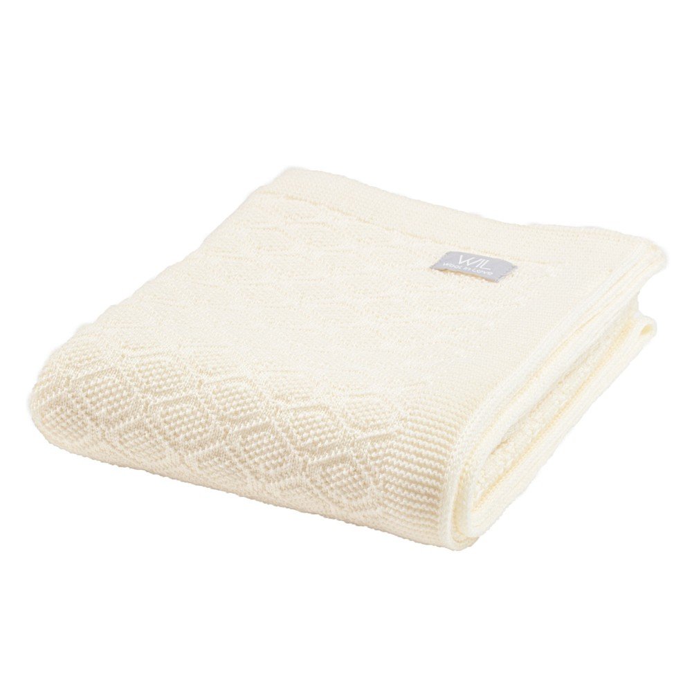 16. Folded cream merino wool baby blanket with brand tag on white background