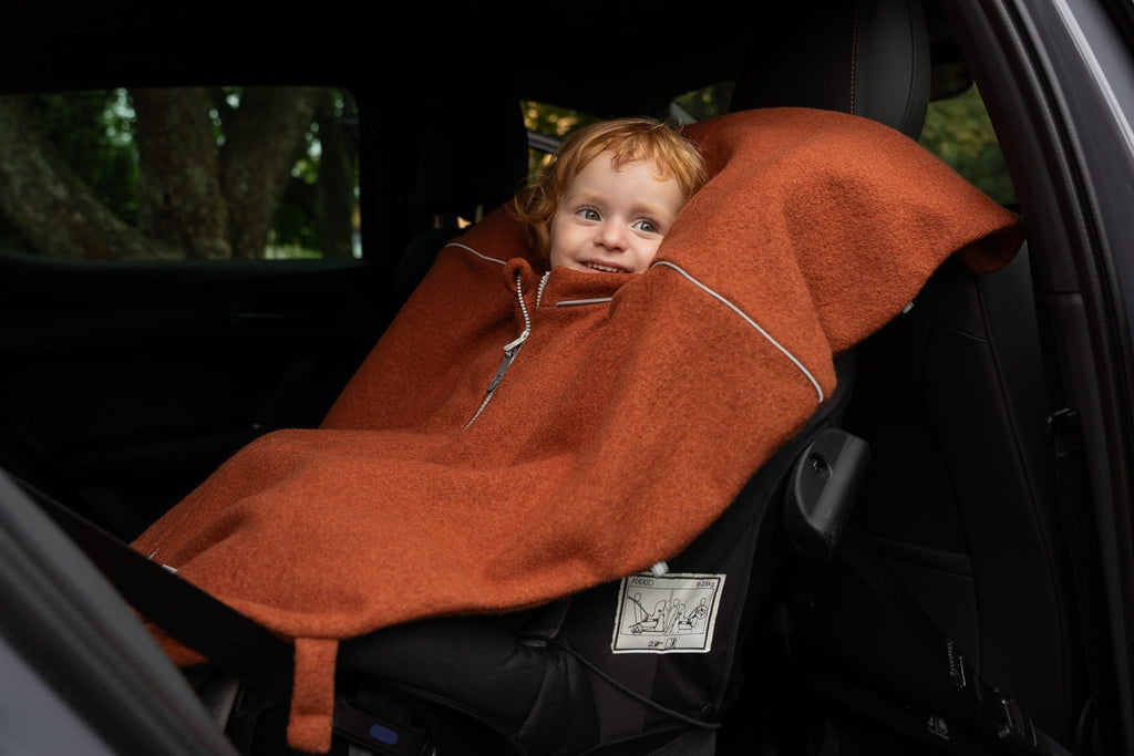 4. Child in car seat wearing brown merino wool poncho with fox ears hood