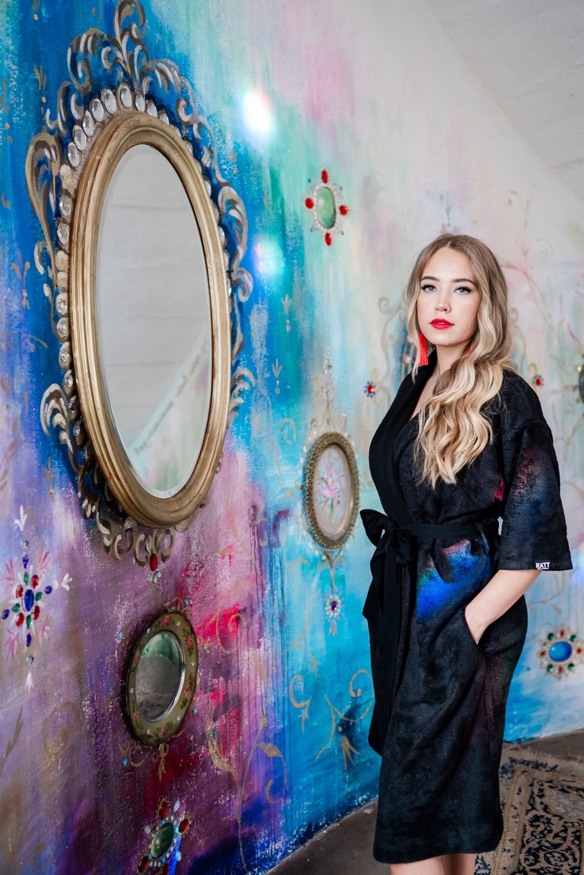 6. Woman in black bamboo terry robe with shawl collar standing by colorful wall with mirrors