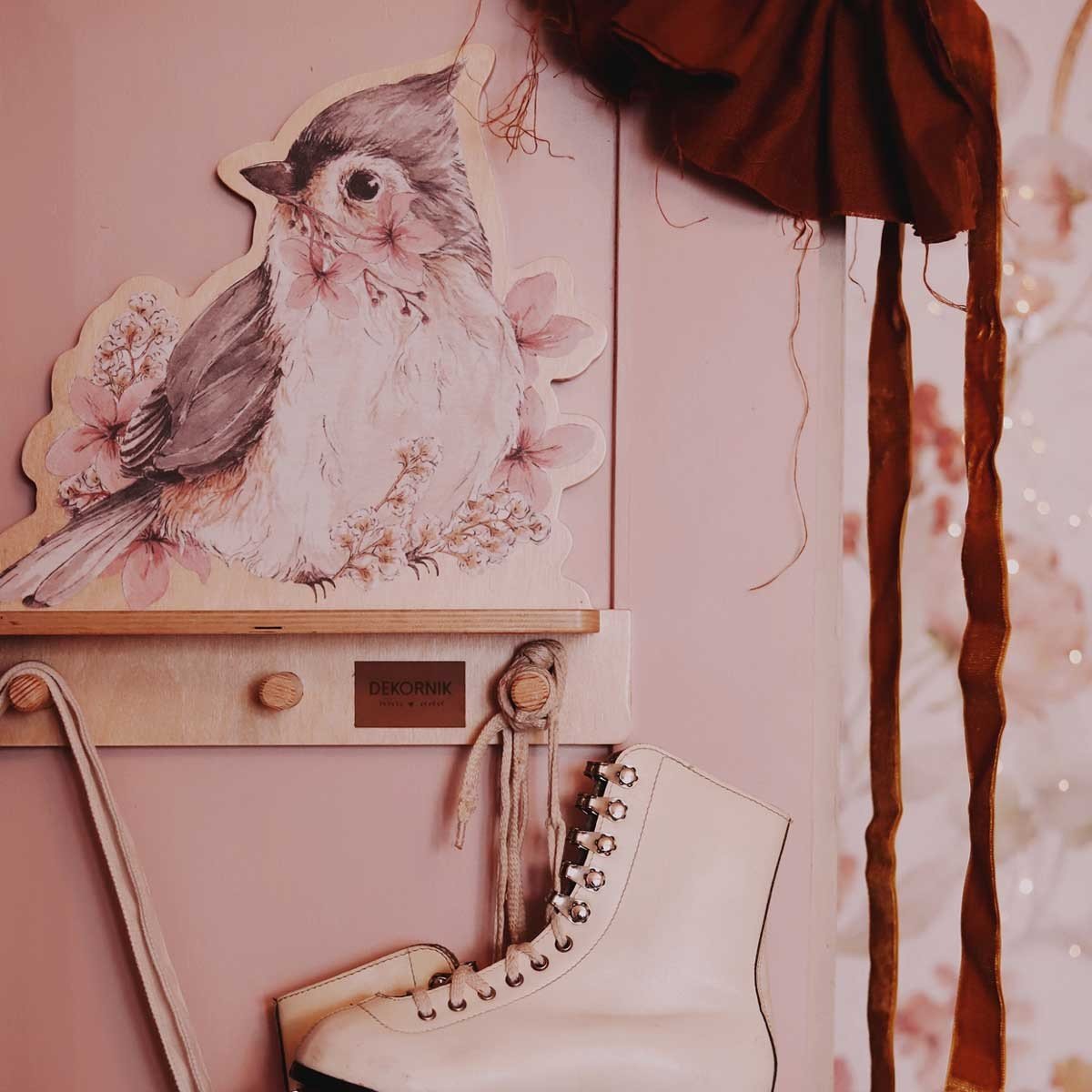6. Close-up of mini wall shelf with bird design, showing Dekornik logo and hanging ice skates