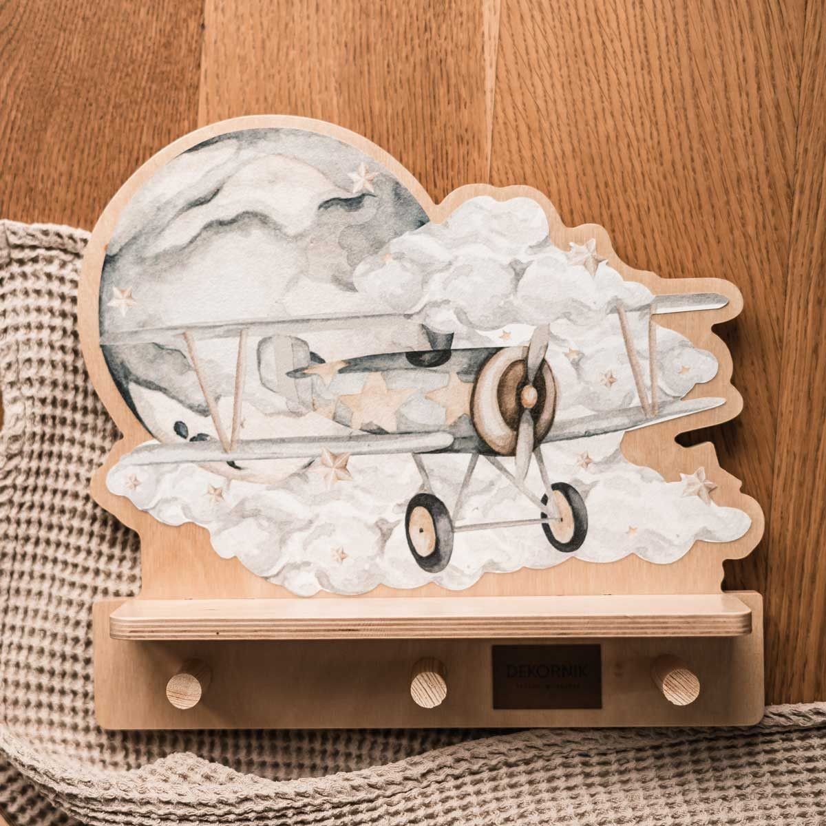 4. Flat lay of Dekornik mini wall shelf with plane design on wooden surface
