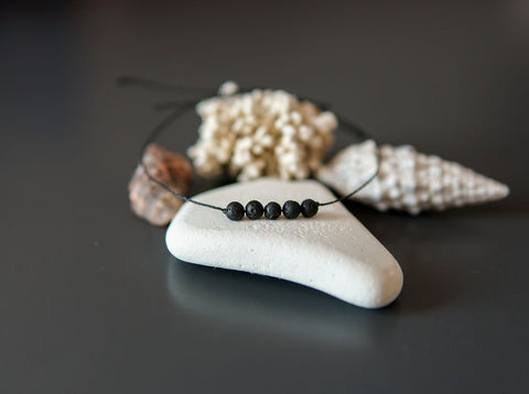 4. Close-up of Canary Lava minimalist lava stone bracelet with natural elements, showcasing polished lava rocks