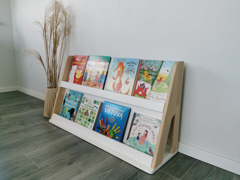 1. Modular Montessori bookshelf with two shelves displaying colorful children's books against a white wall