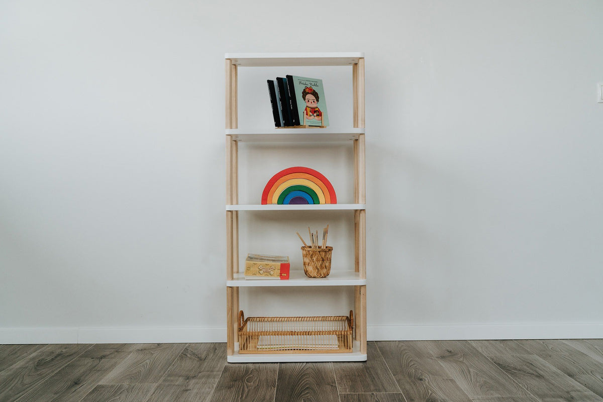 1. Modular Montessori Shelf Straight Mini with five shelves displaying books, a rainbow toy, and art supplies against a white wall on wooden flooring