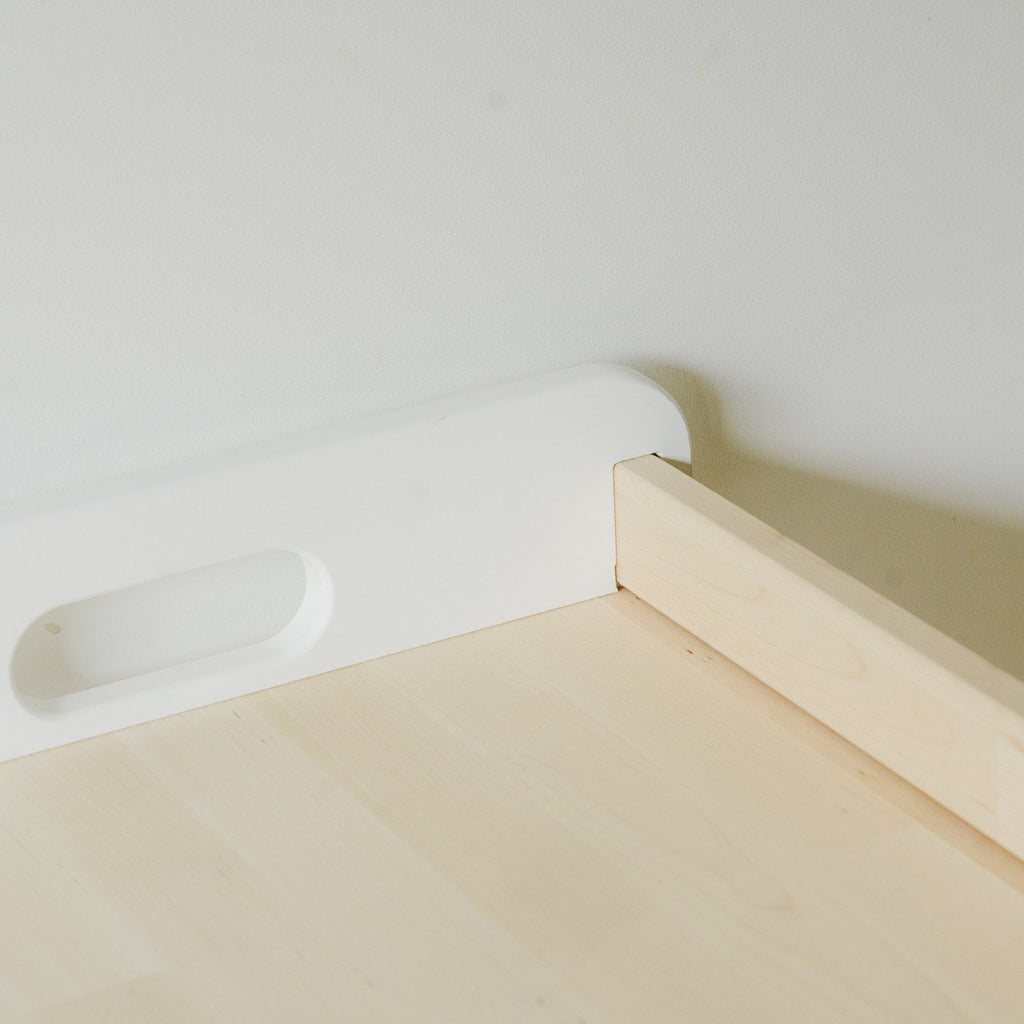 7. Close-up of the corner detail of a Montessori toy shelf, showing white and natural wood finish