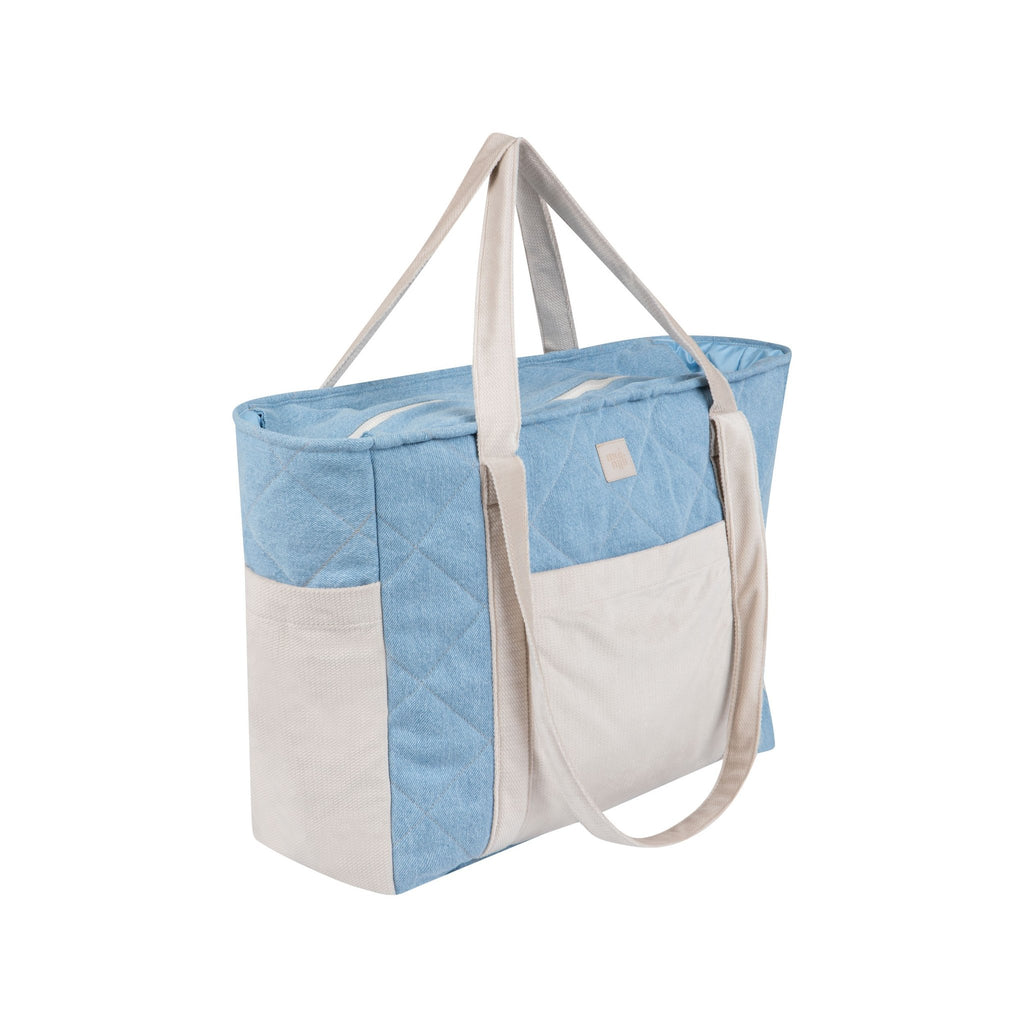 6. Side view of blue and beige quilted weekender bag with long handles in a studio setting